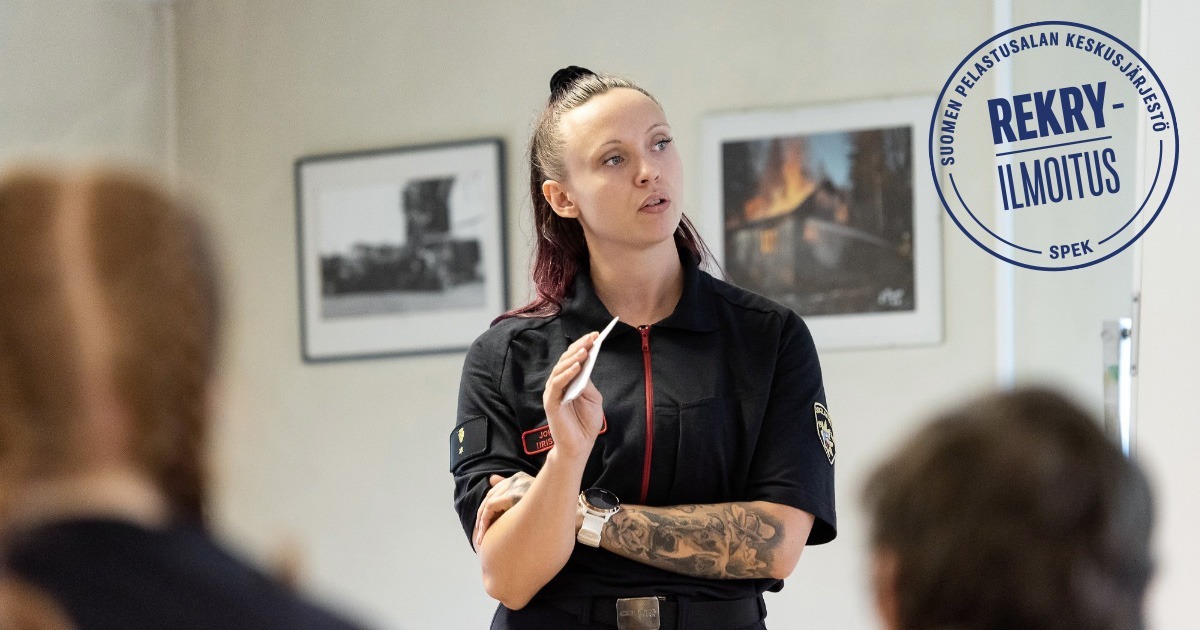 Nainen pukeutunut tummaan asema-asuun ja pitää paperilappua kädessä. Teksti Rekryilmoitus